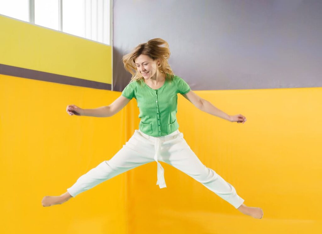 full length young woman standing against yellow wall